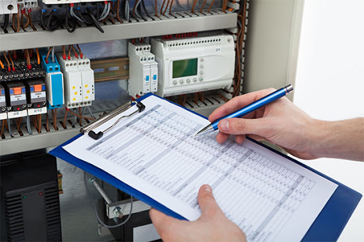 An electrican with a checkboard completing checks on a house.